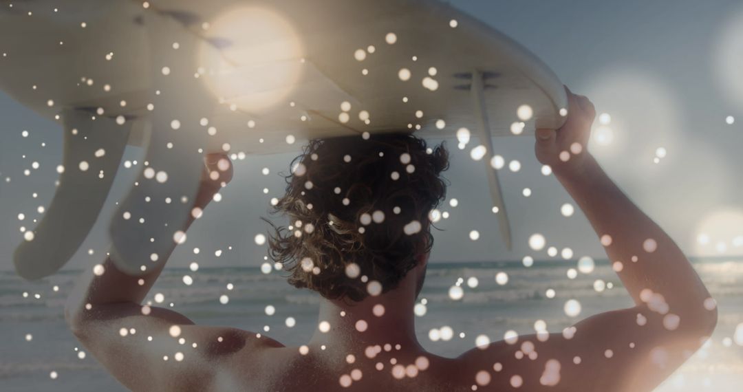 Back View of Surfer with Surfboard on Beach at Sunset