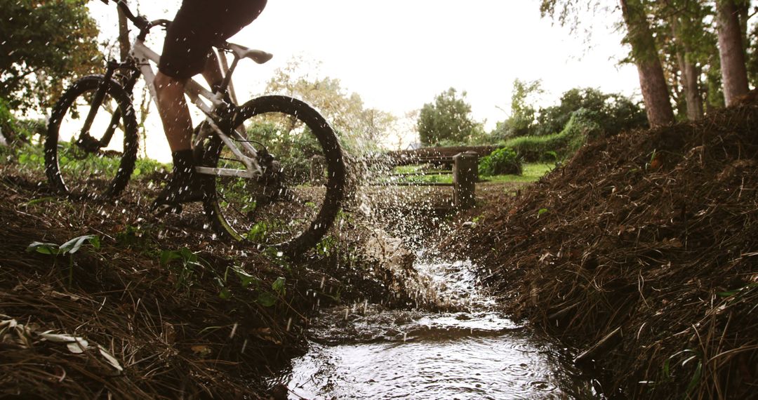 Biker Navigating Through Muddy Puddle on Nature Trail