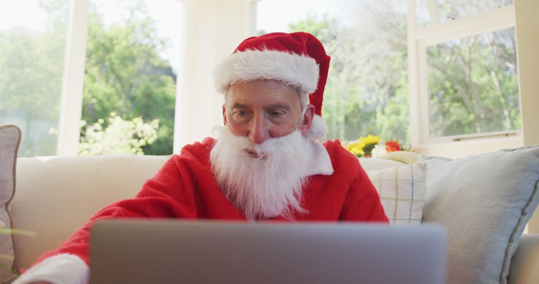 Senior Man in Santa Costume Using Laptop at Home - Free Images, Stock Photos and Pictures on Pikwizard.com