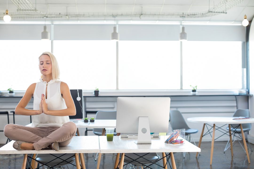 Professional Woman Meditating on Office Desk for Stress Relief