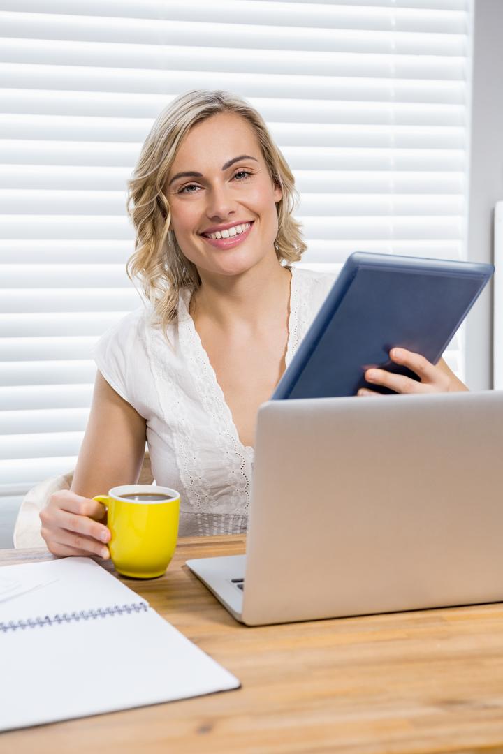 Portrait of beautiful woman holding digital tablet and coffee mug - Free Images, Stock Photos and Pictures on Pikwizard.com