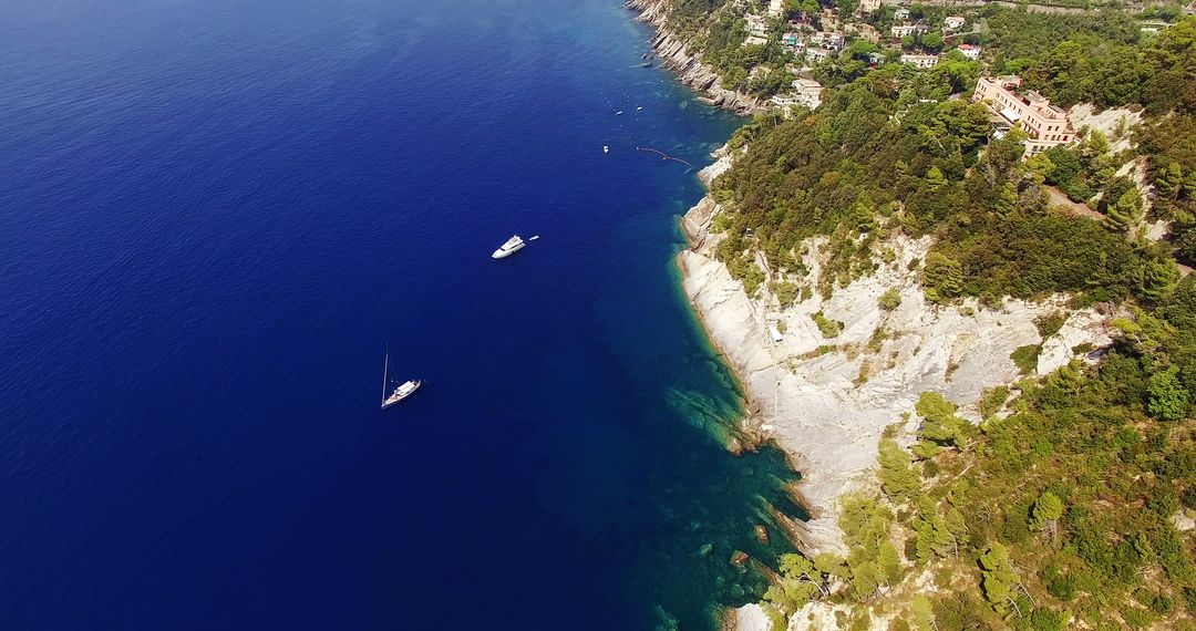 Aerial View of Cliffside Houses and Sailboats on Deep Blue Water - Free Images, Stock Photos and Pictures on Pikwizard.com