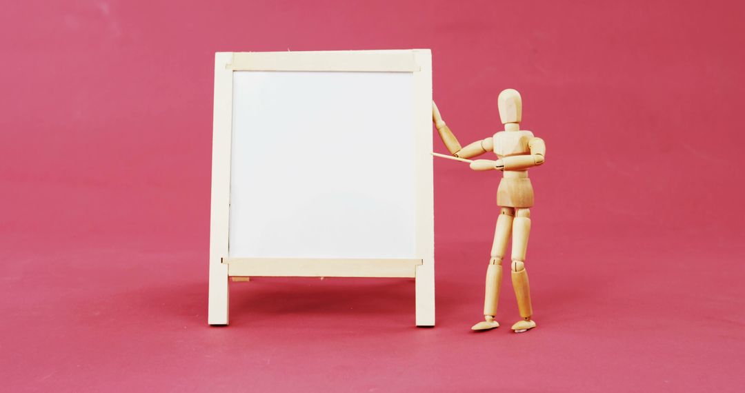 Wooden Dummy Presenting Blank Easel on Red Background - Free Images, Stock Photos and Pictures on Pikwizard.com