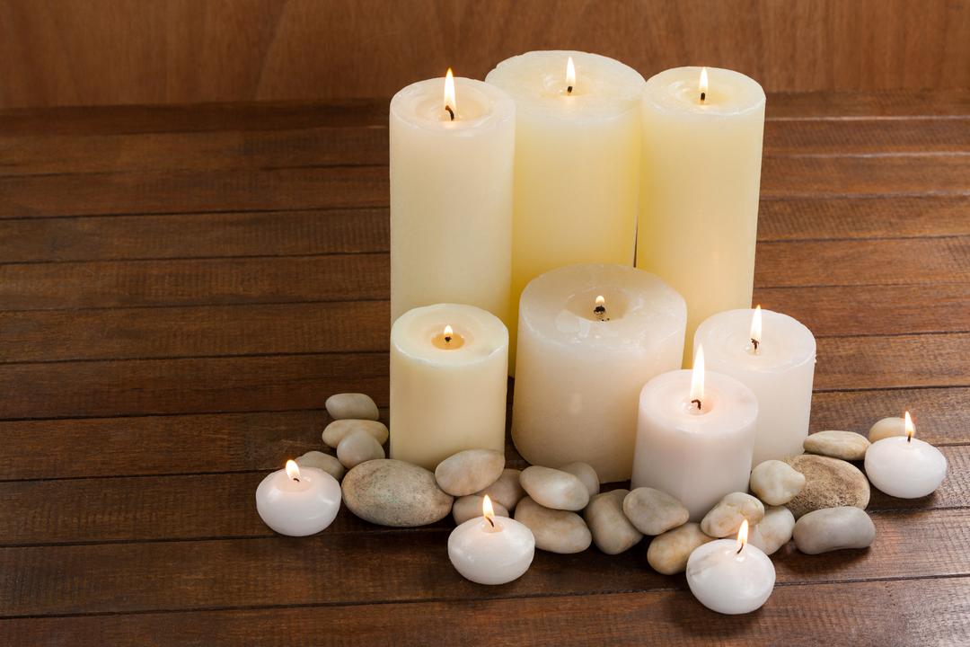 Close- up of white candles and pebbles stone on wood - Free Images, Stock Photos and Pictures on Pikwizard.com