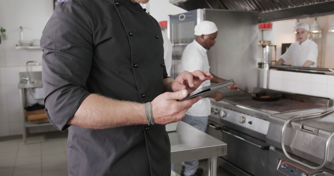 Chef Using Tablet in Professional Kitchen Environment