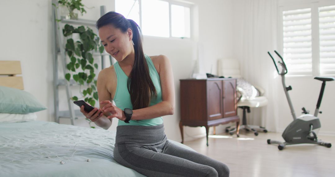 Young Woman Using Smartphone during Home Workout - Free Images, Stock Photos and Pictures on Pikwizard.com