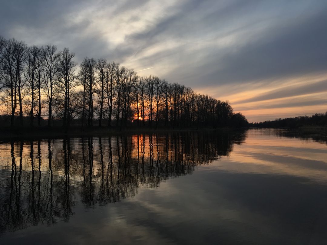 Serene Lake with Dramatic Sunset and Reflective Trees