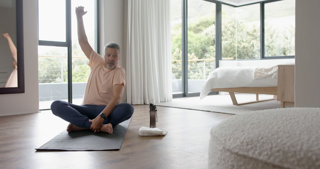 Middle-aged man stretching during morning yoga session at home - Free Images, Stock Photos and Pictures on Pikwizard.com