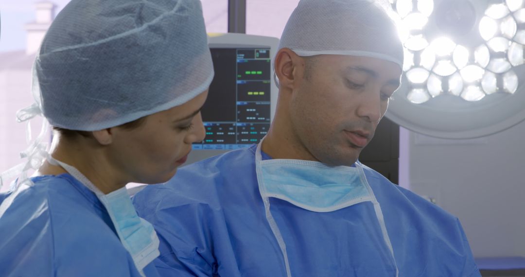 Surgeons Wearing Scrubs and Face Masks Working Intently in Operating Room - Free Images, Stock Photos and Pictures on Pikwizard.com