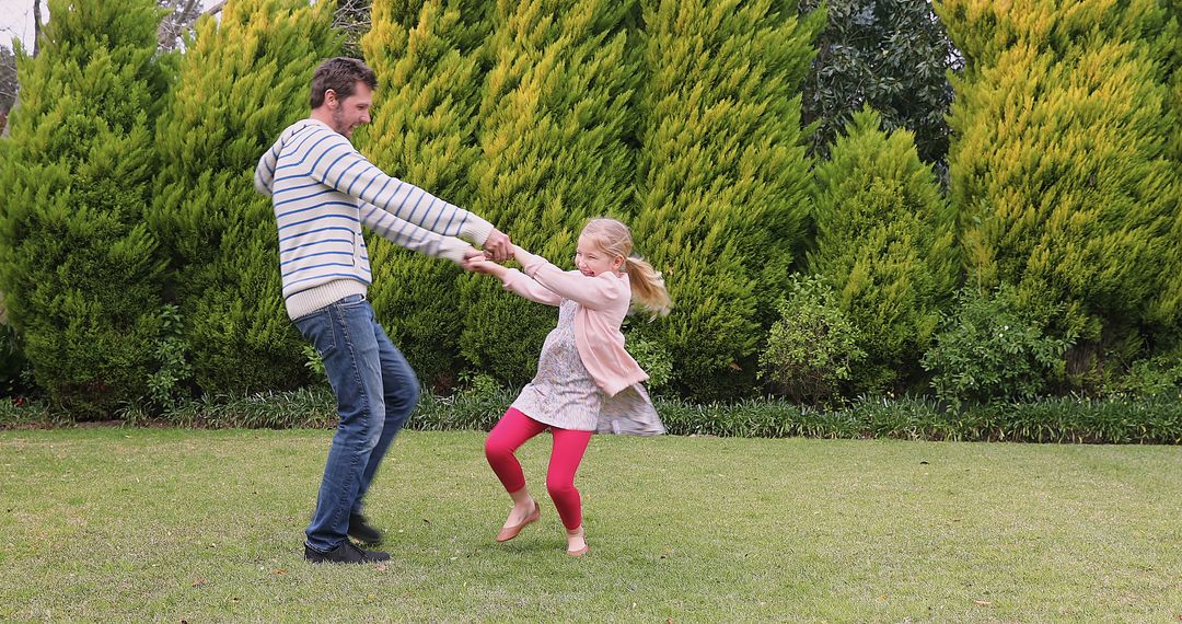 Father Twirling Daughter Outdoors in Garden - Free Images, Stock Photos and Pictures on Pikwizard.com