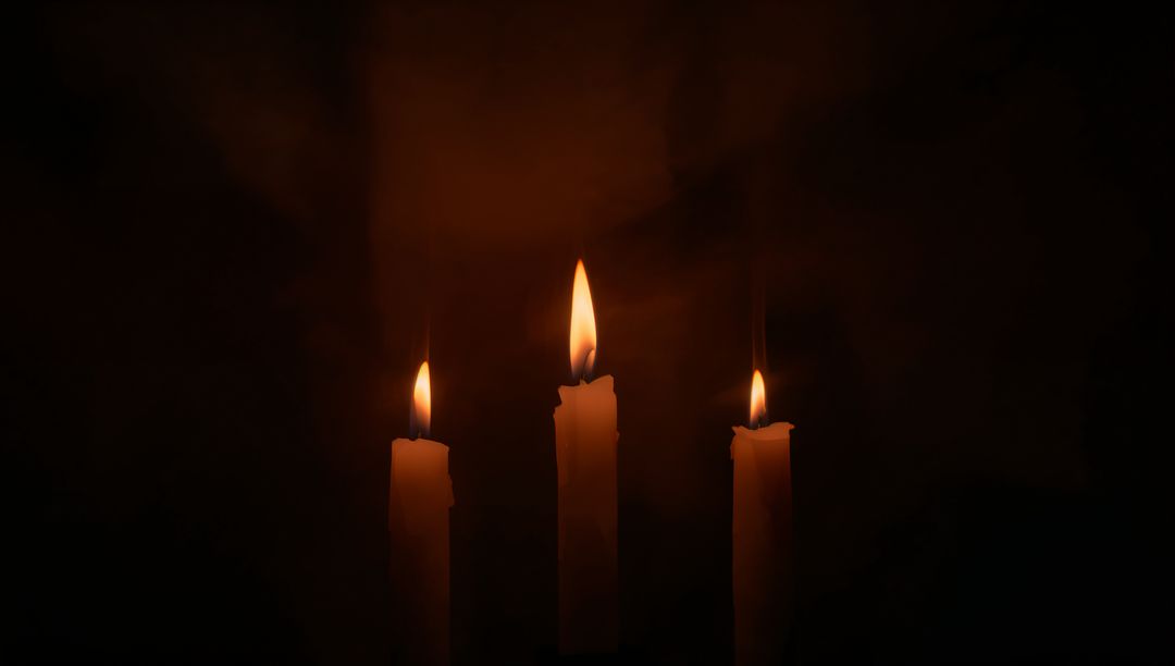 Three Taper Candles Burning with Warm Halo and Dripping Wax in Dark Moody Ambience