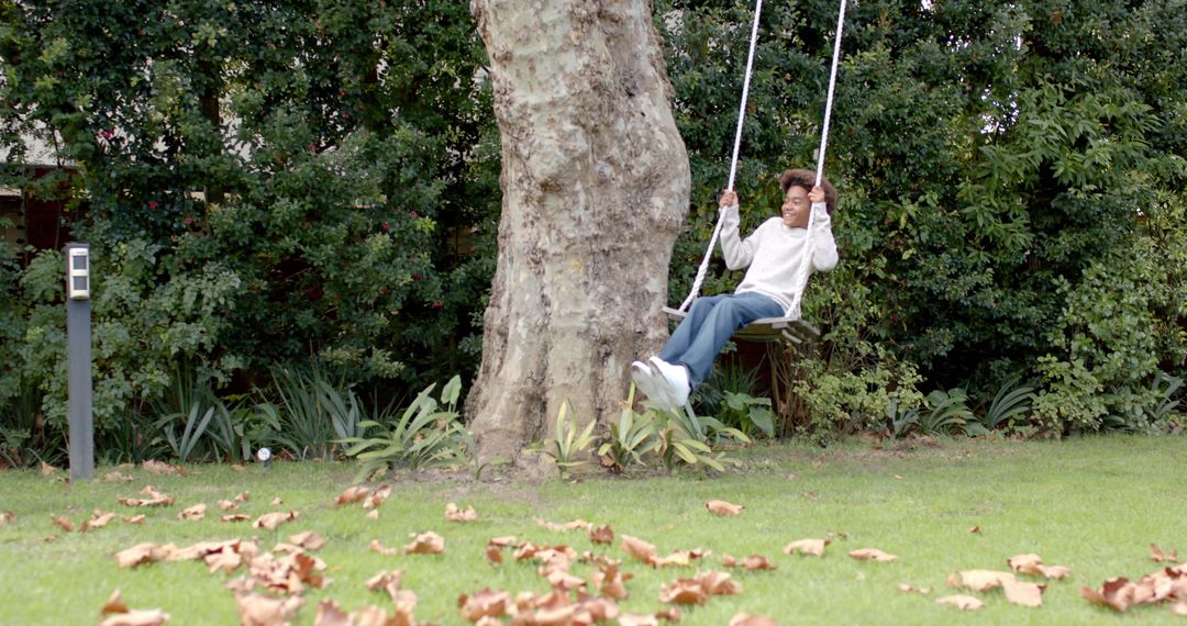 Happy Boy Enjoying Garden Tree Swing in Autumn