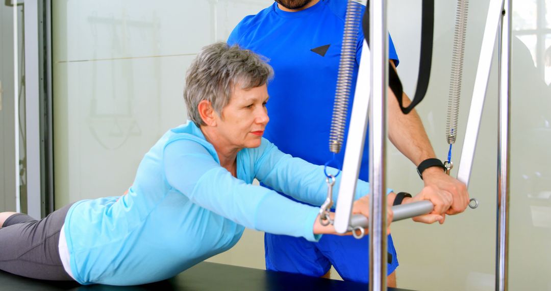 Elderly Woman Training with Physical Therapist on Pilates Reformer - Free Images, Stock Photos and Pictures on Pikwizard.com