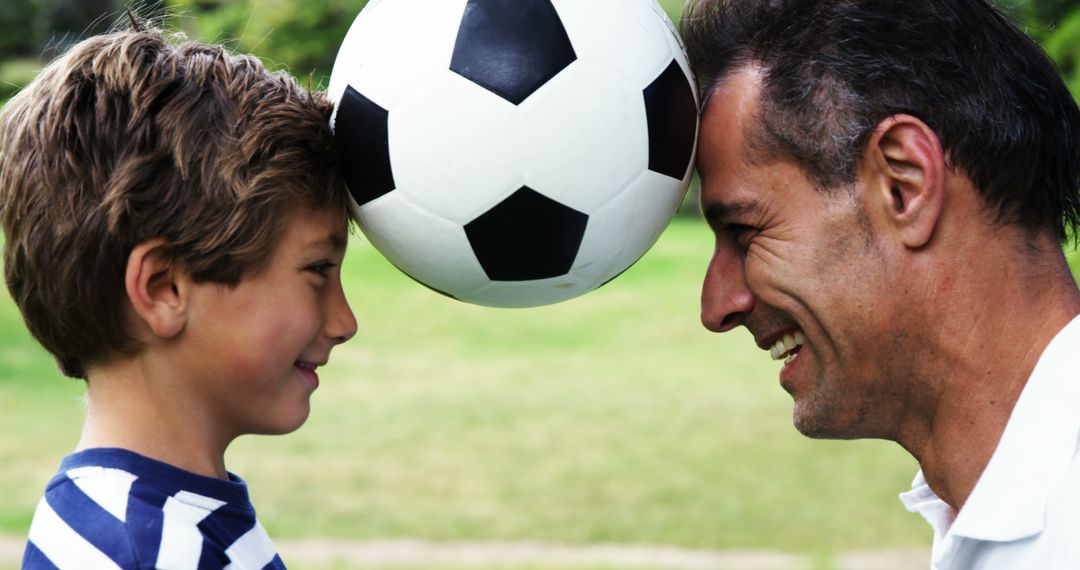 Father and son enjoying soccer game interaction outside - Free Images, Stock Photos and Pictures on Pikwizard.com