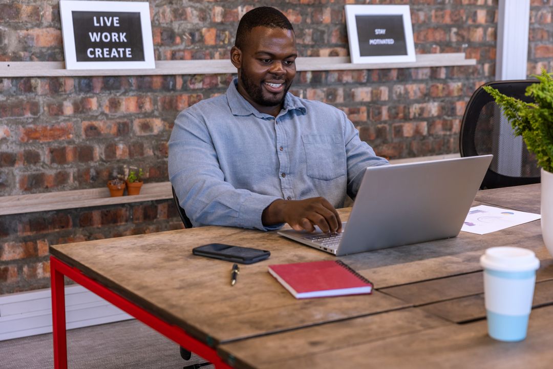 Man Typing on Laptop in Creative Workspace