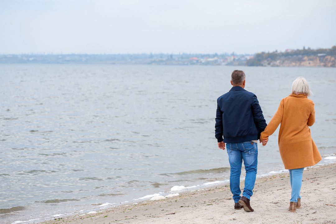 Senior Couple Enjoying Beach Walk in Autumn