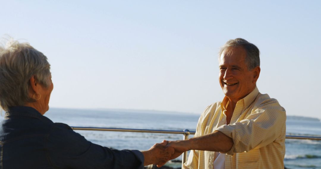 Happy senior caucasian couple holding hands by sea - Free Images, Stock Photos and Pictures on Pikwizard.com