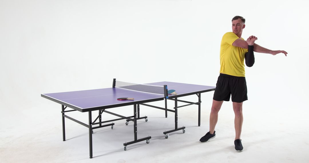Athlete Stretching Near Ping Pong Table for Exercise Routine in Studio