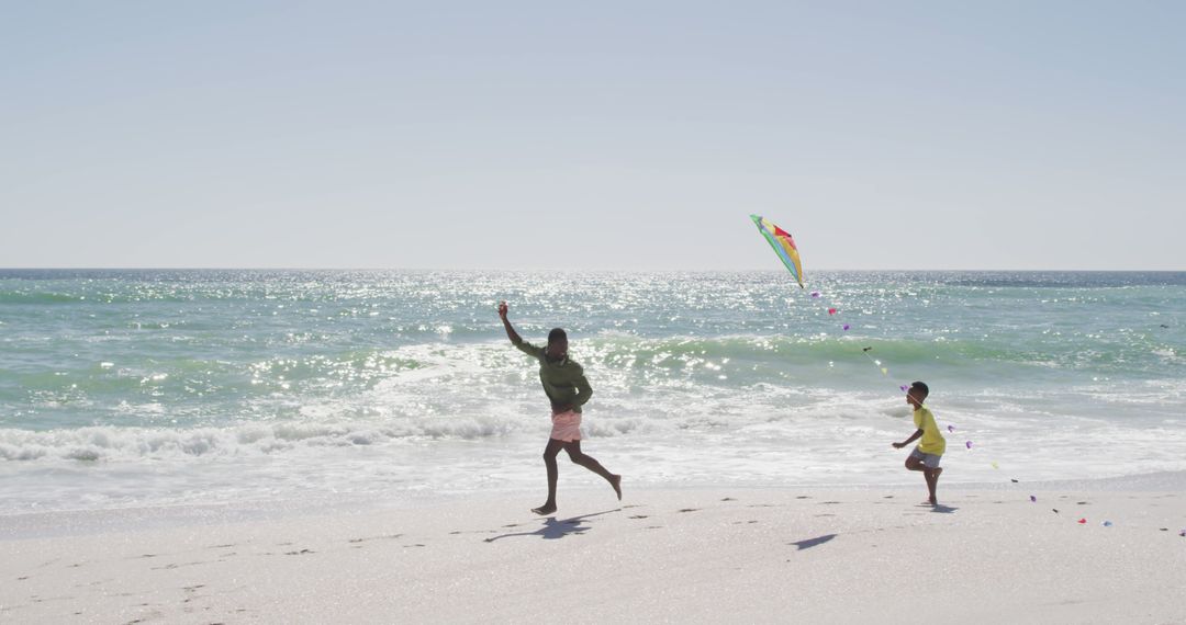 Father and Daughter Flying Kite on Sunny Beach - Free Images, Stock Photos and Pictures on Pikwizard.com