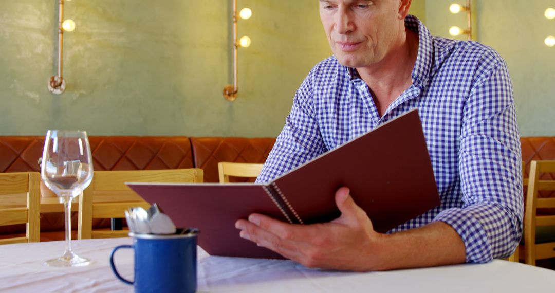 Mature Man Exploring Menu at Cozy Restaurant - Free Images, Stock Photos and Pictures on Pikwizard.com