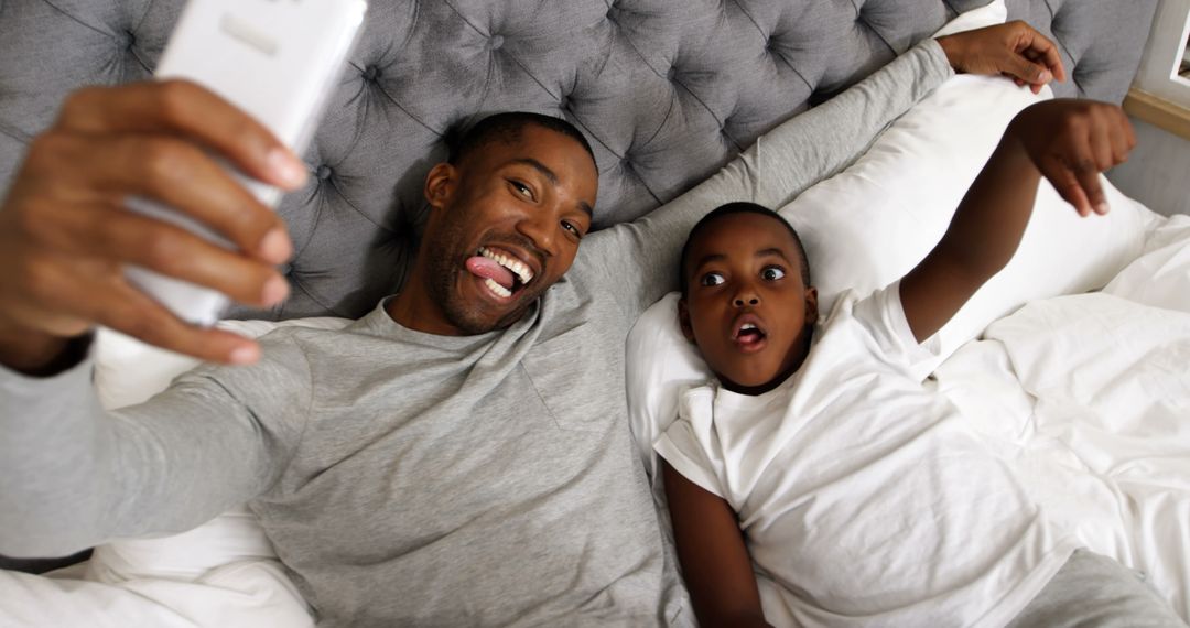 Father and Son Taking Selfie on Bed - Free Images, Stock Photos and Pictures on Pikwizard.com