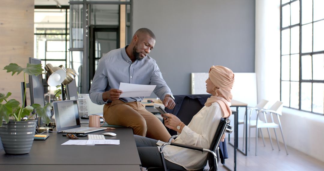 Colleagues Collaborating in Modern Office with Documents and Technology