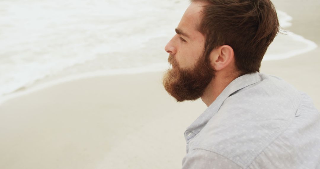 Pensive Man with Beard Looking at Sea on Beach