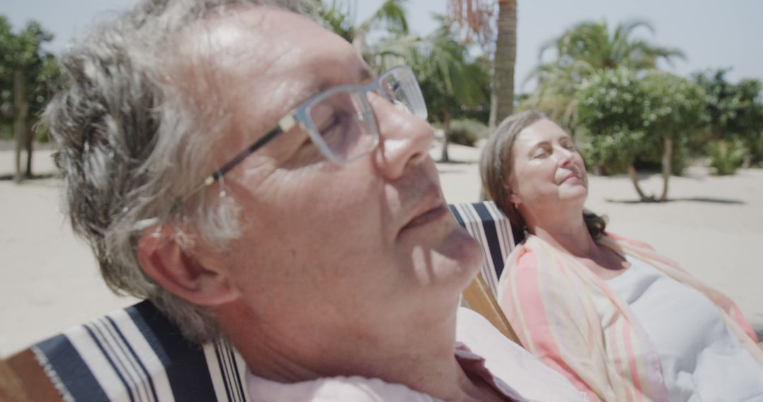 Senior Couple Relaxing on Loungers at Beach Resort - Free Images, Stock Photos and Pictures on Pikwizard.com