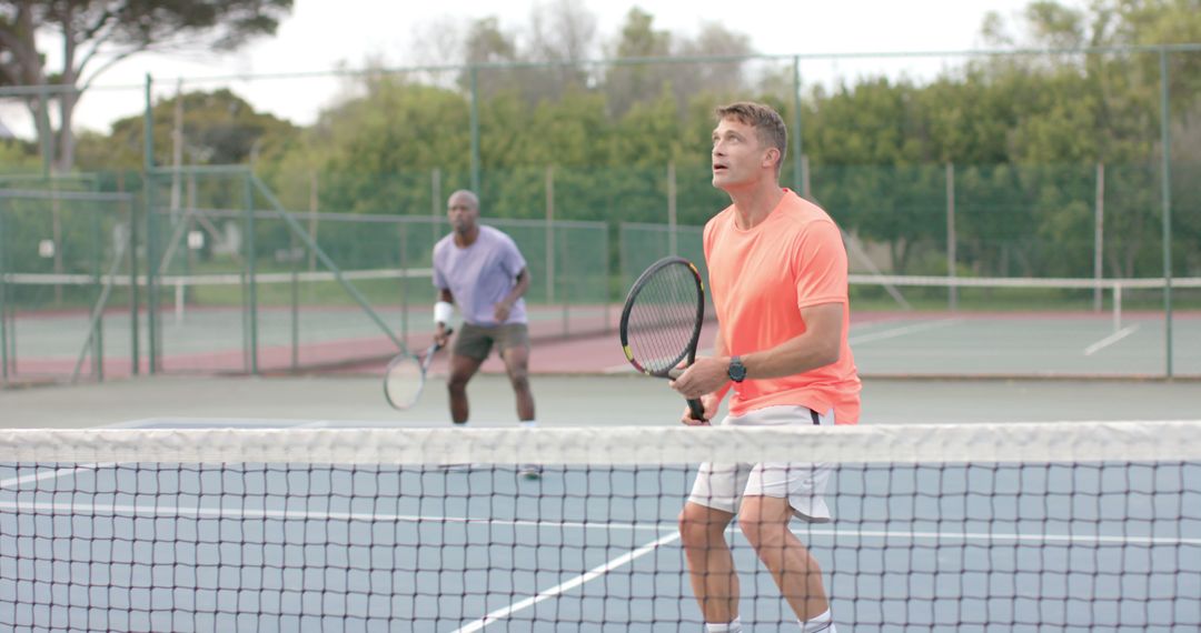 Men Playing Tennis Doubles Focusing Intently - Free Images, Stock Photos and Pictures on Pikwizard.com