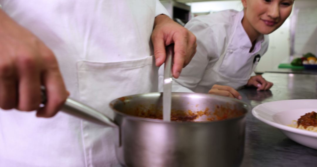 Chefs Preparing Dish in Professional Kitchen - Free Images, Stock Photos and Pictures on Pikwizard.com