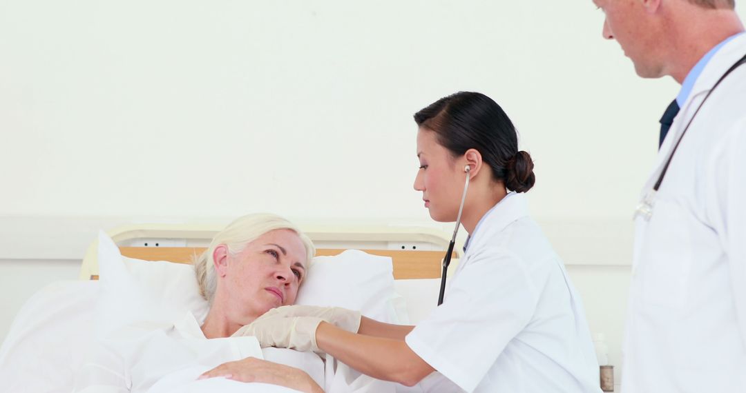 Medical Team Caring for Elderly Female Patient in Hospital Bed - Free Images, Stock Photos and Pictures on Pikwizard.com