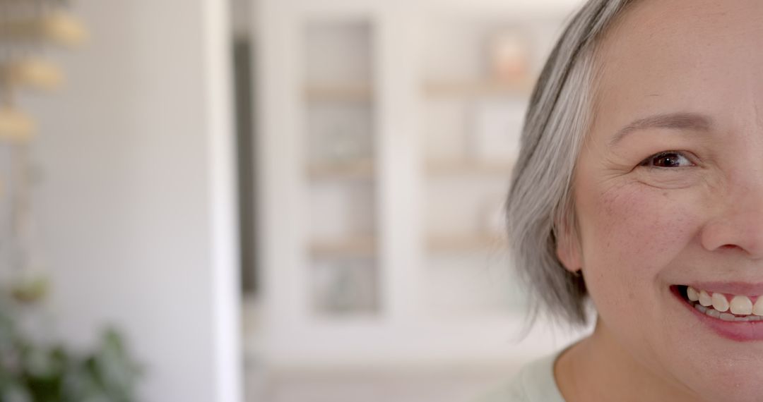 Elderly Asian Woman Smiling Joyfully in Bright Home Interior