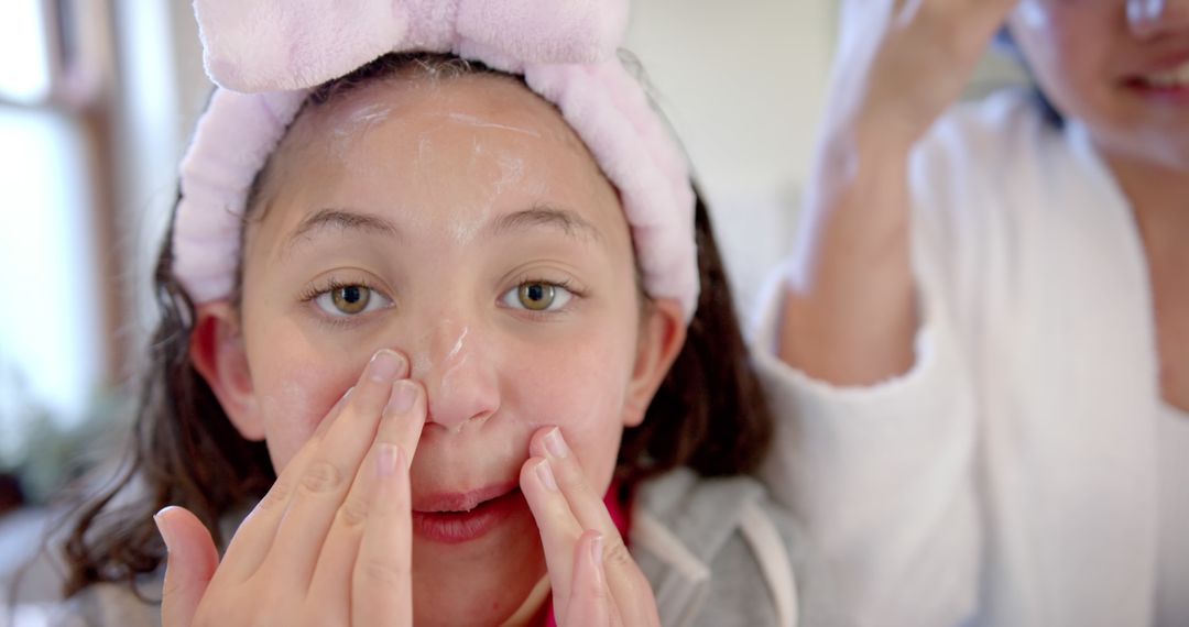 Young Girl Applying Facial Cream During Skincare Routine - Free Images, Stock Photos and Pictures on Pikwizard.com