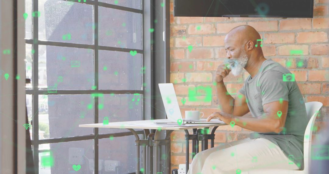 Bearded Man Using Laptop in Modern Cafe with Icon Graphics