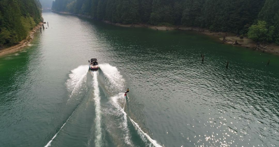 Aerial View of Boat Towing Water Skier on Tranquil River - Free Images, Stock Photos and Pictures on Pikwizard.com