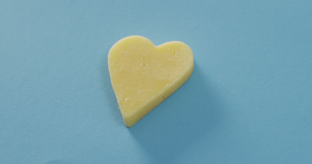 Yellow Heart-Shaped Object on Light Blue Background - Free Images, Stock Photos and Pictures on Pikwizard.com