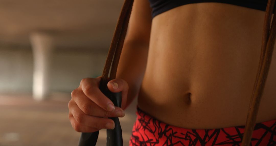 Close Up of Woman's Midriff Holding Skipping Rope in Urban Environment