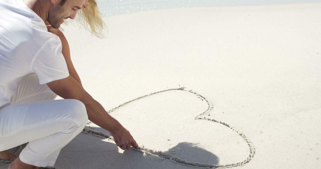 Couple Drawing Heart in Sand on Sunny Beach - Free Images, Stock Photos and Pictures on Pikwizard.com