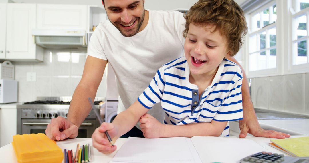 Father Helping Son with Homework in Kitchen, Smiling and Learning Together - Free Images, Stock Photos and Pictures on Pikwizard.com