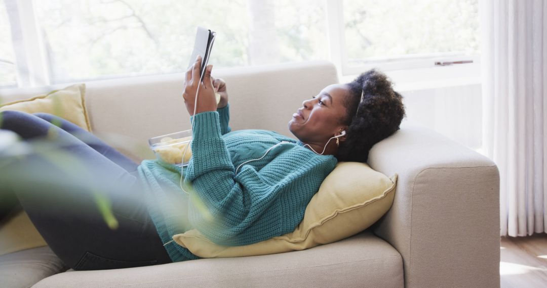 Woman Relaxing on Couch with Tablet and Earphones - Free Images, Stock Photos and Pictures on Pikwizard.com