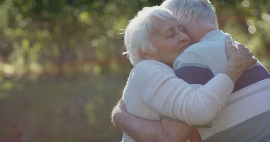 Elderly Couple Embracing in Sunlit Garden - Free Images, Stock Photos and Pictures on Pikwizard.com