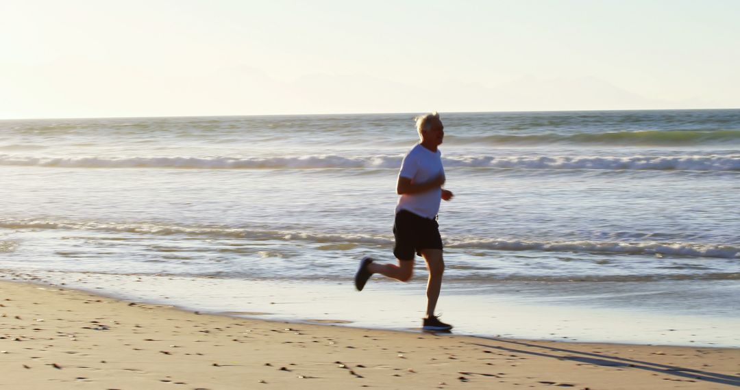 Active Senior Man Jogging on the Beach at Sunrise - Free Images, Stock Photos and Pictures on Pikwizard.com