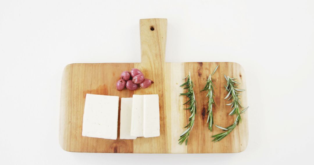 A wooden board displays cheese, grapes, and rosemary, perfect for food-themed visuals. - Free Images, Stock Photos and Pictures on Pikwizard.com