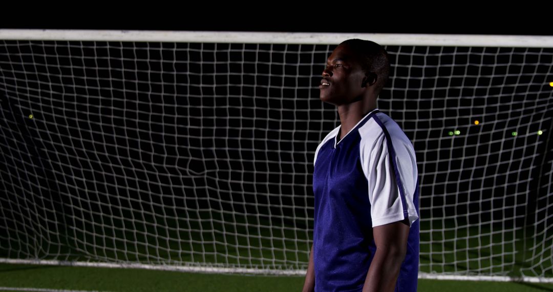 Soccer Player Practicing at Night on Field in Blue Jersey