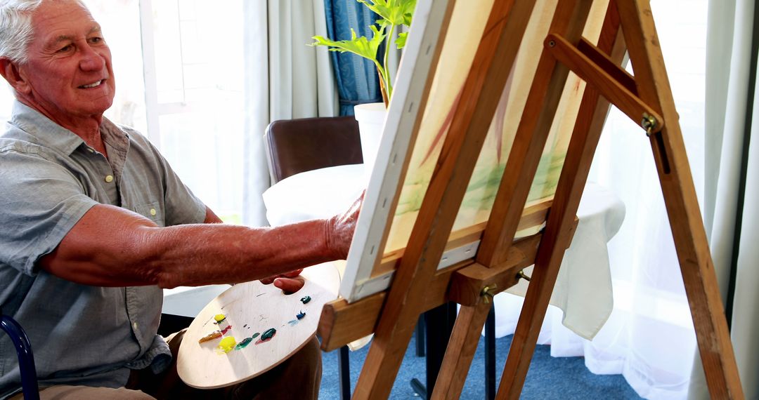 Elderly Man Painting on Easel at Home - Free Images, Stock Photos and Pictures on Pikwizard.com