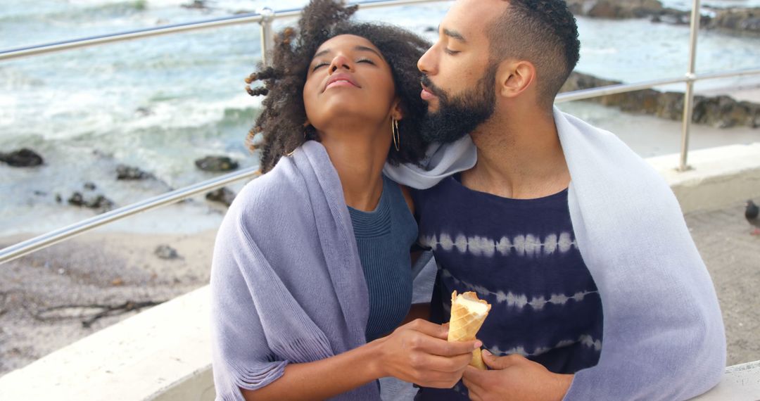 Young African American Couple Enjoying Ice Cream by the Ocean - Free Images, Stock Photos and Pictures on Pikwizard.com