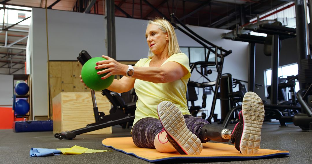 Active Senior Woman with Prosthetic Leg Exercising with Medicine Ball in Gym - Free Images, Stock Photos and Pictures on Pikwizard.com