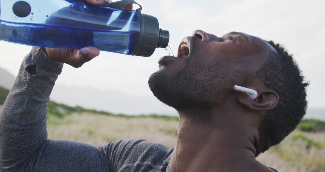 Athletic Black Man Hydrating with Water Bottle on Nature Hike - Free Images, Stock Photos and Pictures on Pikwizard.com