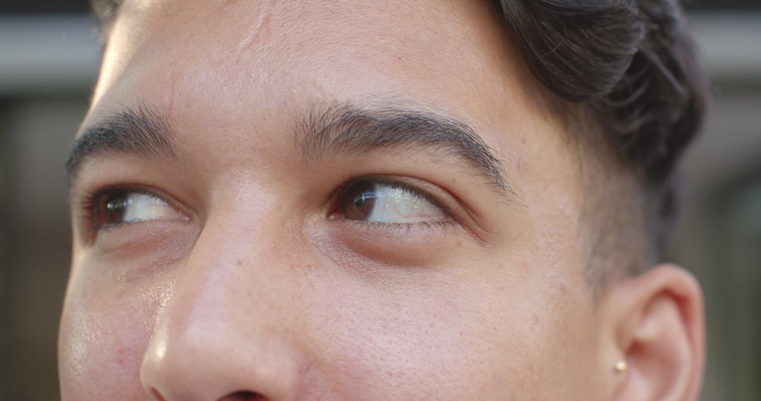 Close-Up Portrait of Man with Introspective Gaze Through Blurred Slats