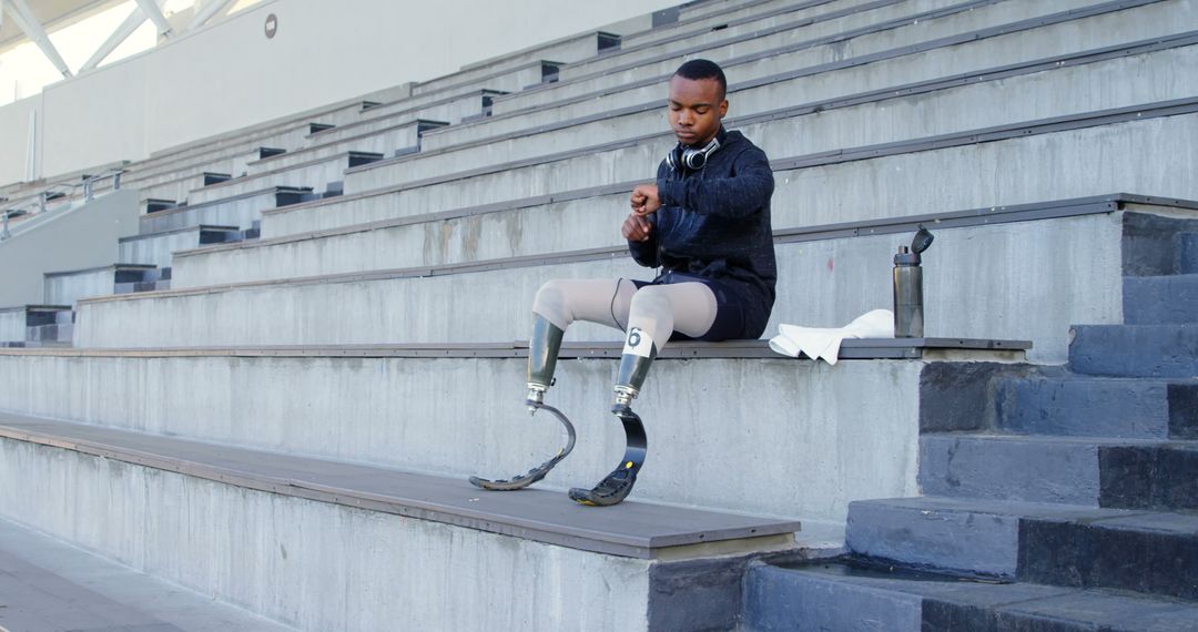 Adaptive Athlete with Prosthetic Legs Preparing for Training in Stadium - Free Images, Stock Photos and Pictures on Pikwizard.com